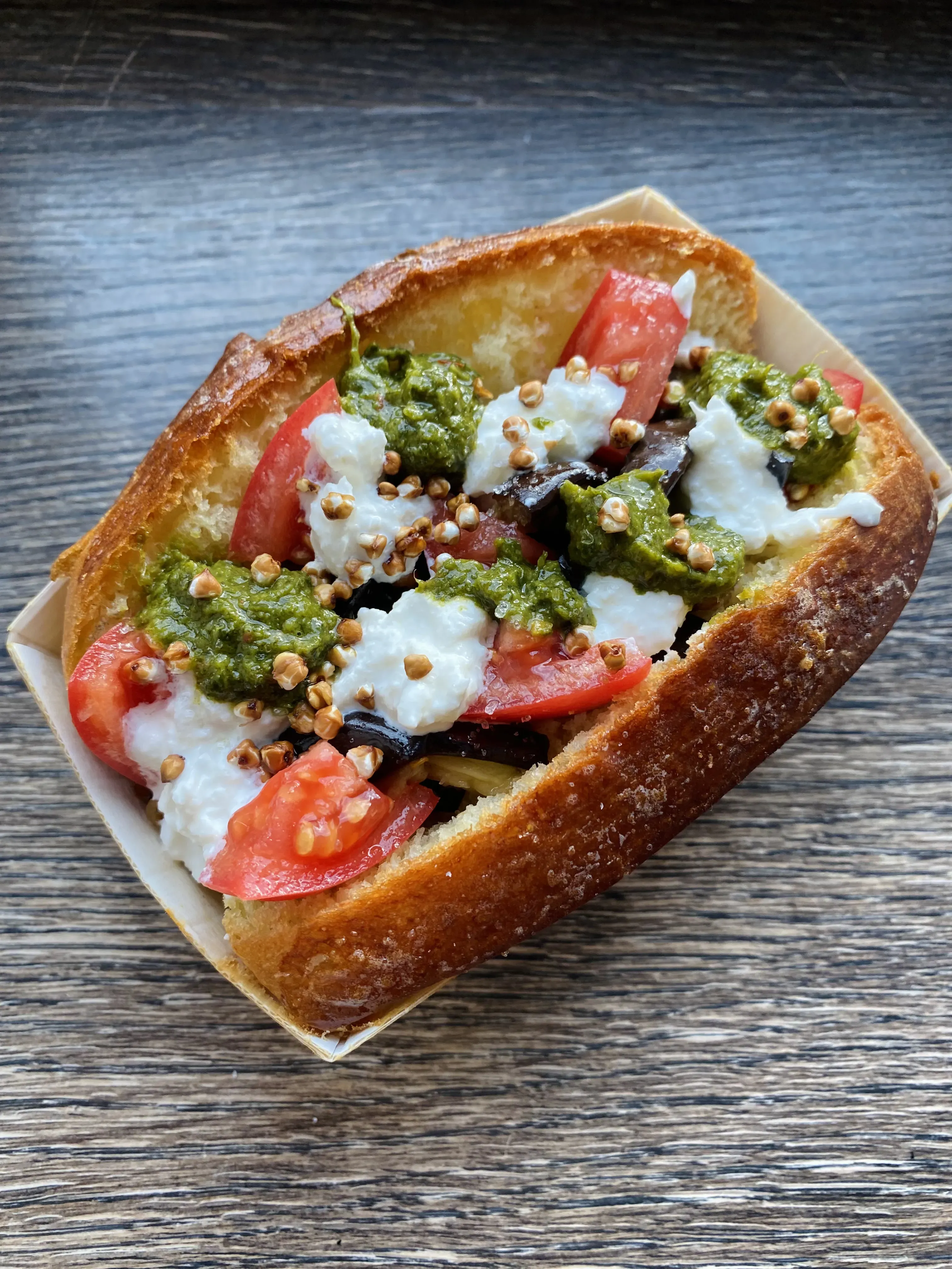 Pesto bagel with tomato, mozzarella, and buckwheat