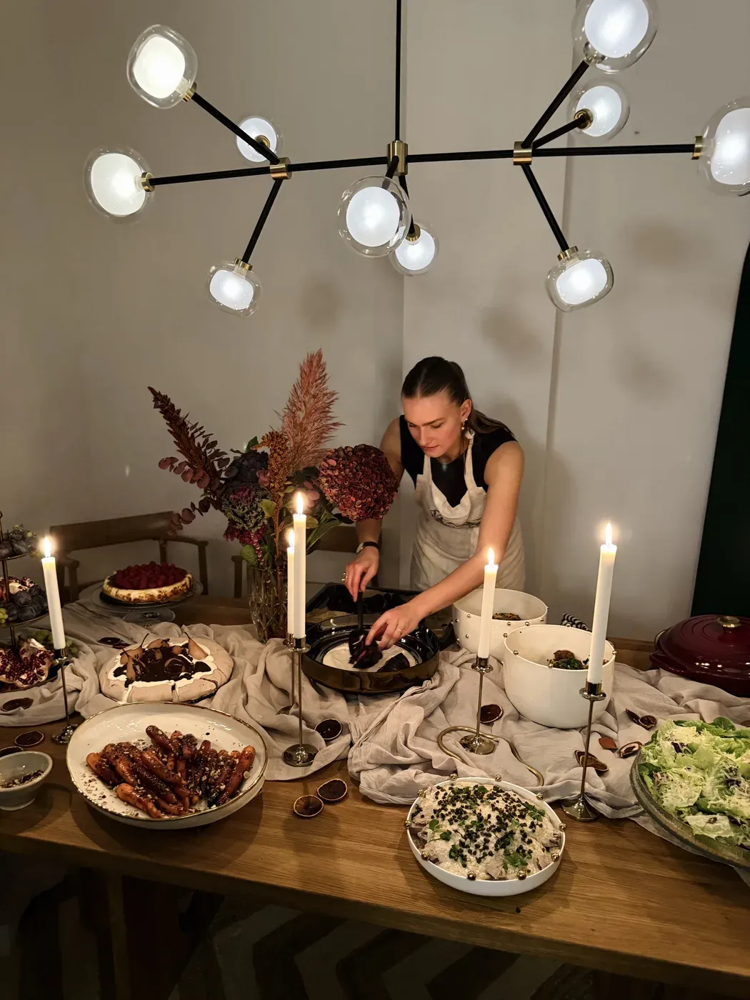 Līva setting a candlelit supper table