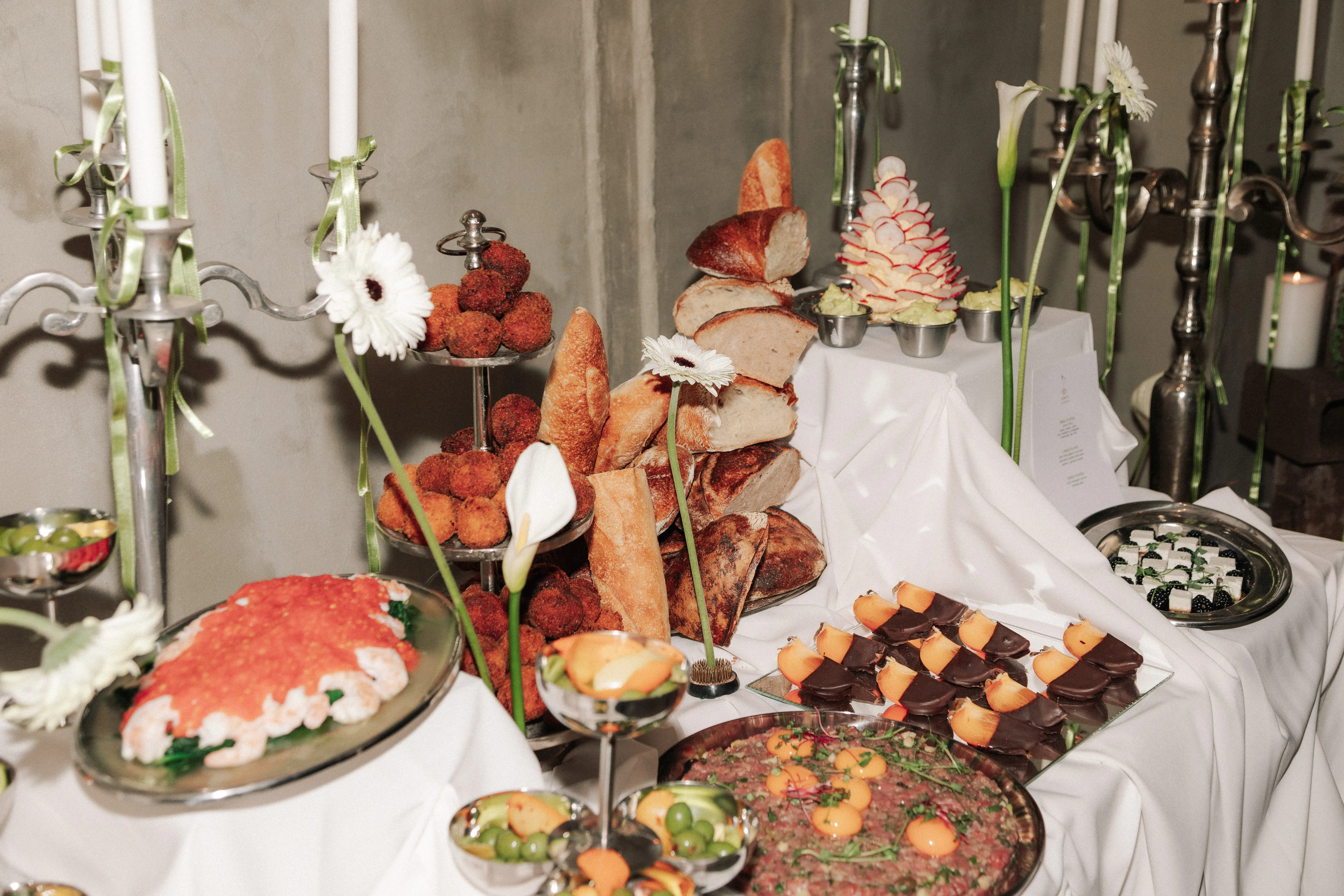 An elegant catering buffet spread with bread, pastries, and seasonal dishes
