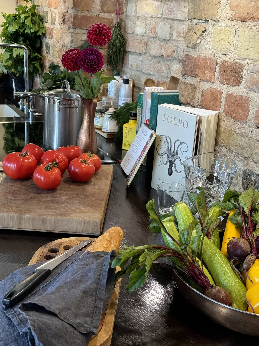 The mana kitchen — brick walls, fresh produce, and cookbooks