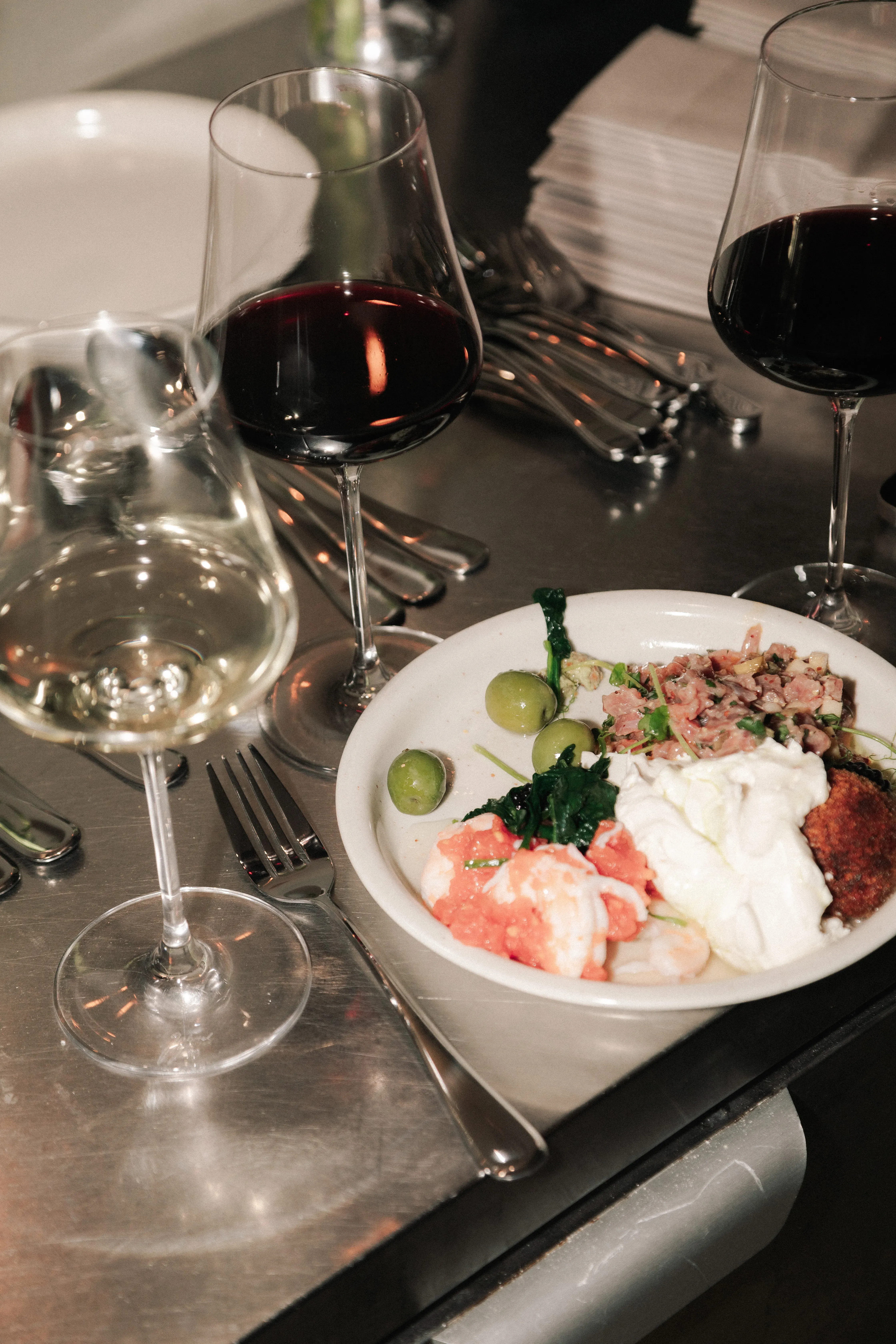 Wine glasses and a beautifully plated dish at a supper club evening